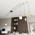 Lampa wisząca Fuji w kolorze czarnym i złotym, zawierająca sześć źródeł światła E14/GU10/GX53. Zawieszona na cienkich linkach, z różnorodnymi kloszami w stylu nowoczesnym. Widoczna w aranżacji wnętrza z regałem i biurkiem.