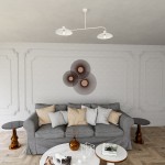 Lampa wisząca Foster 2xE27 w kolorze białym, z dwoma okrągłymi kloszami. Ujęcie z góry, zawieszona nad szarym sofą w nowoczesnym wnętrzu. Elementy dekoracyjne w tle w odcieniach brązu i złota, na prostym tle.