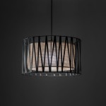 Lampa wisząca Harmony z oprawą w kolorze czarnym i brązowym, o okrągłym kształcie. Metalowy klosz z geometrycznym wzorem, odsłaniający wewnętrzny materiał w odcieniu brązowym. Zawieszona na cienkim przewodzie, na ciemnym tle.