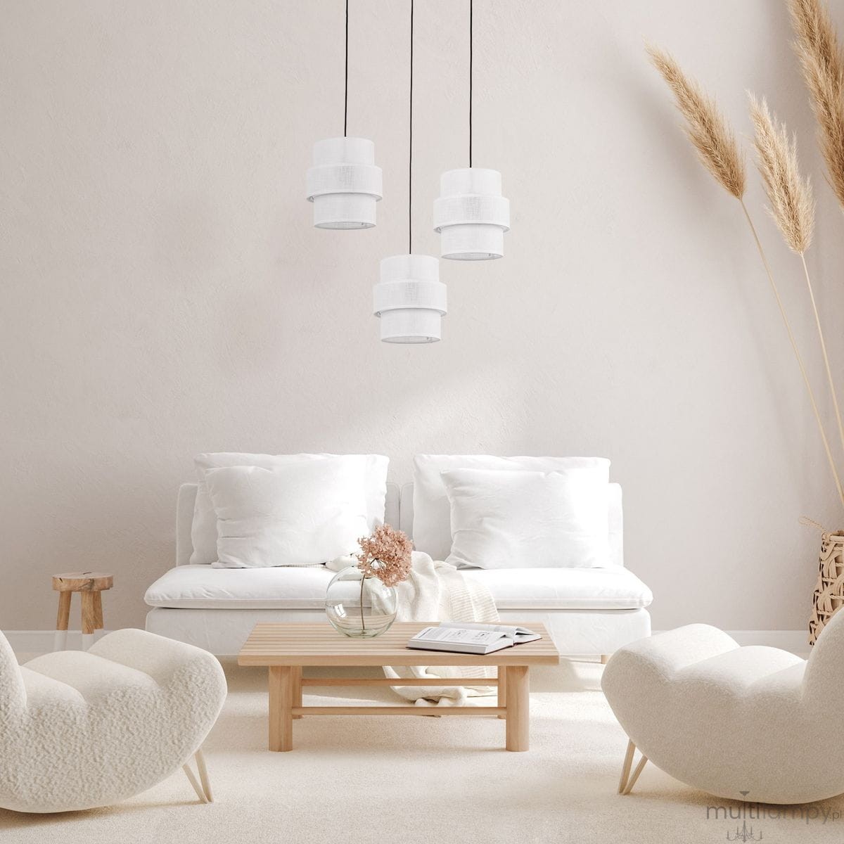 Lampa wisząca Calisto 3xE27 w kolorze czarnym i białym z trzema okrągłymi kloszami, wisząca na czarnych przewodach. Produkt umieszczony nad niskim drewnianym stolikiem w minimalistycznym wnętrzu z białymi sofami i dekoracjami.