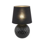 Lampa stołowa Santana z żarówką E27, z okrągłą podstawą o fakturze w kształcie diamentu, w kolorze czarnym. Abajur z tkaniny w kolorze czarnym, wewnętrzna strona w złotym odcieniu. Ujęcie frontalne, lampa stoi na płaskiej powierzchni.