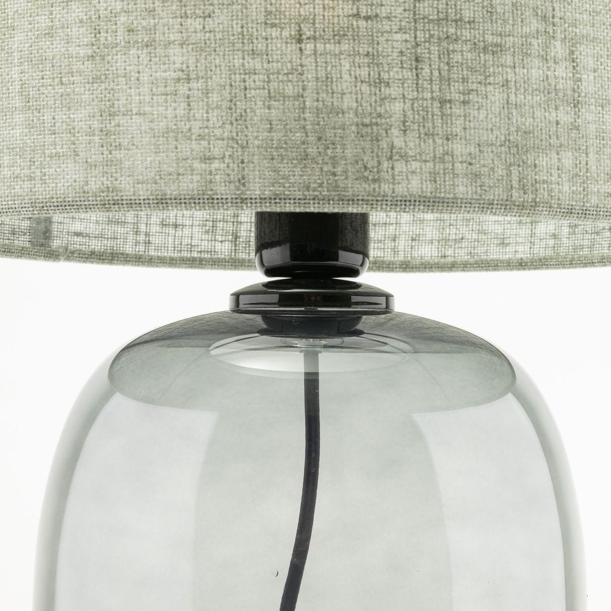 Lampa stołowa Melody z grafitowym, szklanym podstawą i zielonym, tekstylnym kloszem. Ujęcie z góry, pokazujące detale łączenia klosza z podstawą oraz widoczną przewód elektryczny.