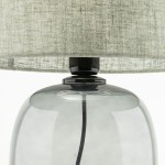 Lampa stołowa Melody z grafitowym, szklanym podstawą i zielonym, tekstylnym kloszem. Ujęcie z góry, pokazujące detale łączenia klosza z podstawą oraz widoczną przewód elektryczny.
