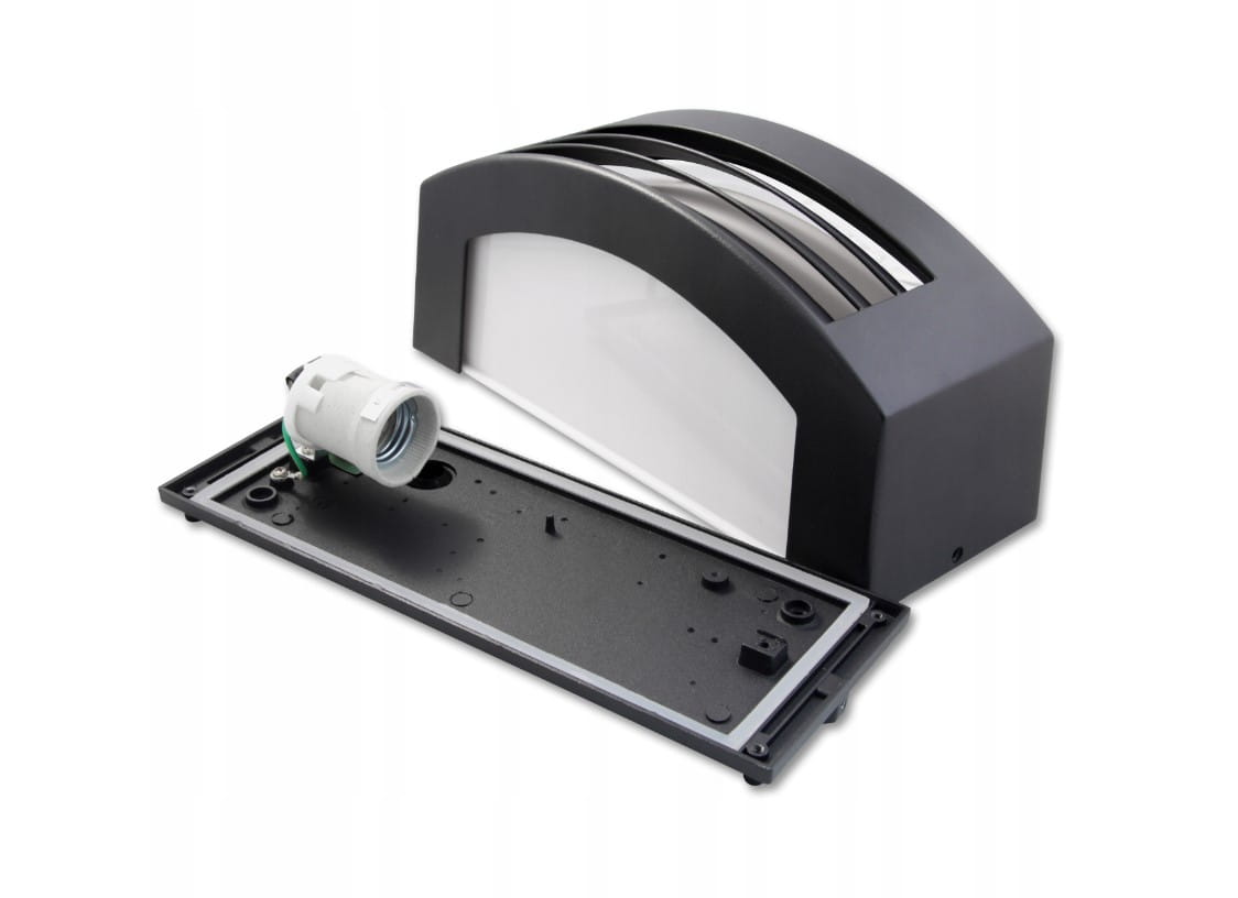 Kinkiet elewacyjny Corso w kolorze antracytowym, z oprawą na jedną żarówkę E27. Widoczny element montażowy oraz przezroczysta osłona. Produkt leży na płaskiej powierzchni, ukazując detale konstrukcji.