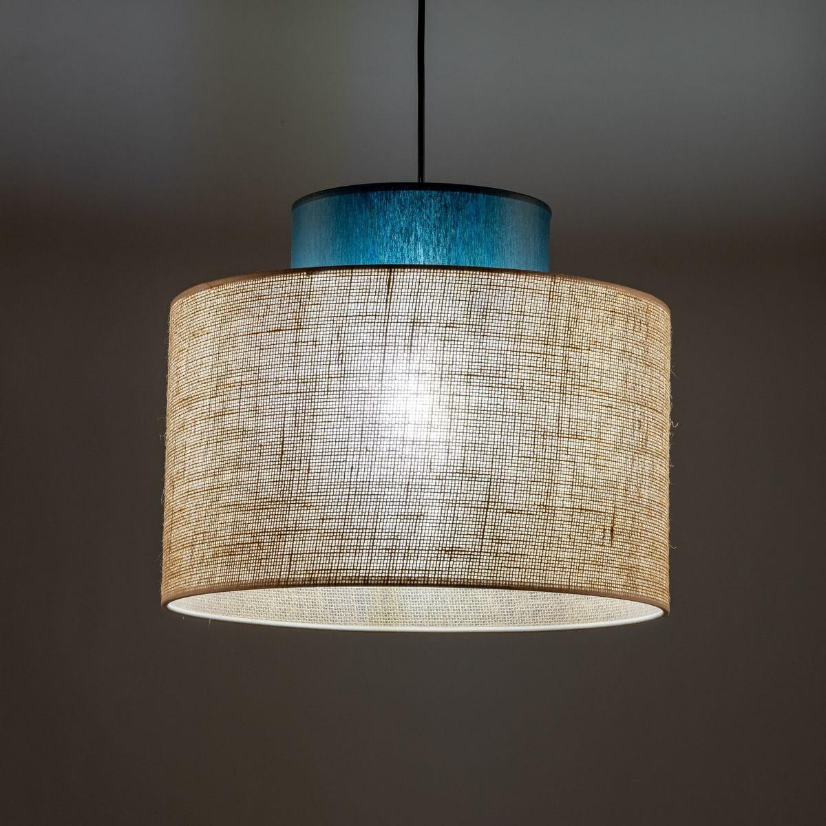 Lampa wisząca Duo D38 z kloszem z juta w kolorze naturalnym i metalowym elementem w odcieniu zielonym. Ujęcie z dołu, ukazujące okrągły kształt klosza oraz źródło światła wewnątrz. Prosta, nowoczesna konstrukcja idealna do różnych aranżacji wnętrz.