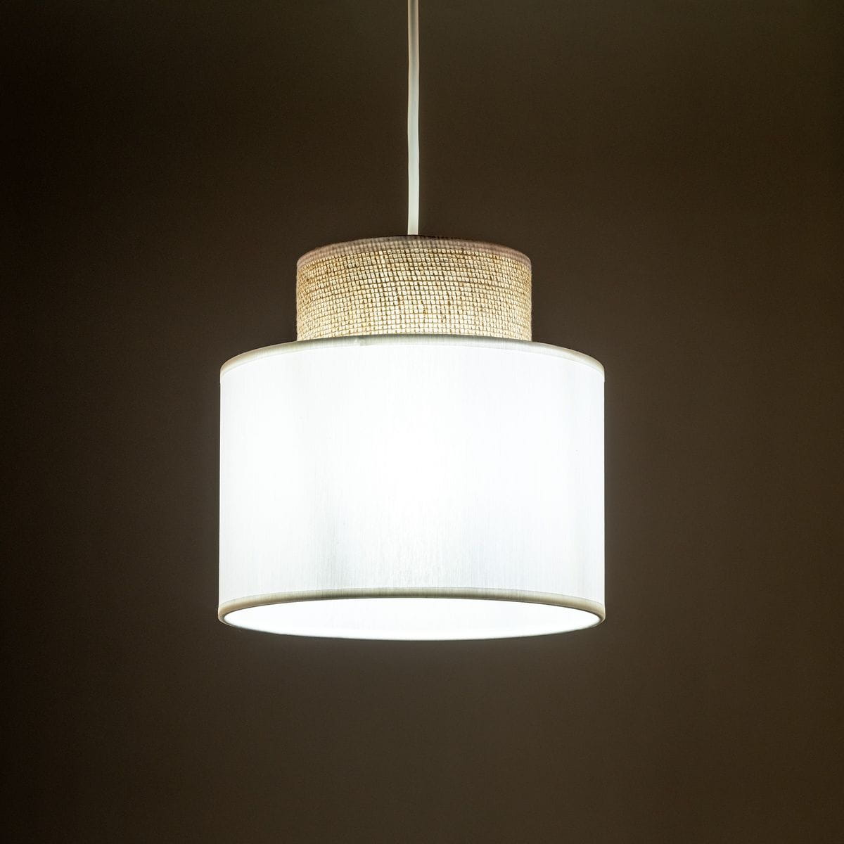 Lampa wisząca Duo D20 z białym kloszem i jutowym detalem, zawieszona na białym przewodzie. Kształt cylindryczny, z widocznym połączeniem materiałów. Idealna do nowoczesnych wnętrz.