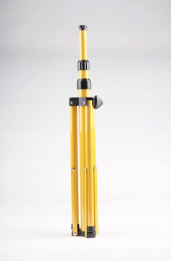 Przenośny statyw naświetlacza LED w kolorze żółtym, złożony, z widocznymi teleskopowymi segmentami. Górna część z mocowaniem i pokrętłem do regulacji wysokości. Tło białe, co podkreśla konstrukcję statywu.