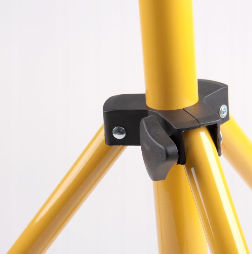 Zbliżenie na złącze statywu naświetlacza LED. Widoczne trzy żółte nogi statywu z czarnym mocowaniem. Elementy metalowe są wyraźnie widoczne, a statyw jest ustawiony w pozycji rozłożonej, gotowy do użycia.