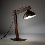 Brązowa lampa biurkowa Oslo z metalowym kloszem w kształcie półkuli, umocowana na drewnianej podstawie. Ujęcie z boku, pokazujące wyłącznik na przewodzie. Wysoka, minimalistyczna konstrukcja, idealna do biura lub domowego wnętrza.