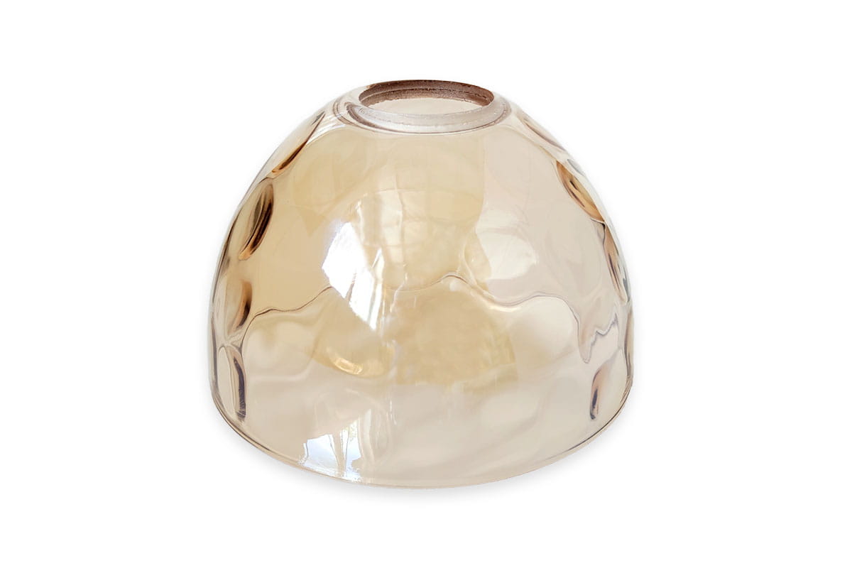 Klosz szklany Mori w kształcie półkuli o średnicy 150 mm, transparentny bursztynowy. Wykończony z delikatnym efektem, z widocznym otworem na górze. Ułożony na białym tle, z lekko zaokrąglonym kształtem i gładką powierzchnią.