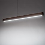 Lampa wisząca Teo o długości prostokątnej, wykonana z ciemnego drewna z czarnym przewodem. Posiada wbudowane oświetlenie LED o mocy 13W, emitujące jasne światło na całej długości. Ujęcie frontalne, zawieszona na dwóch linkach.