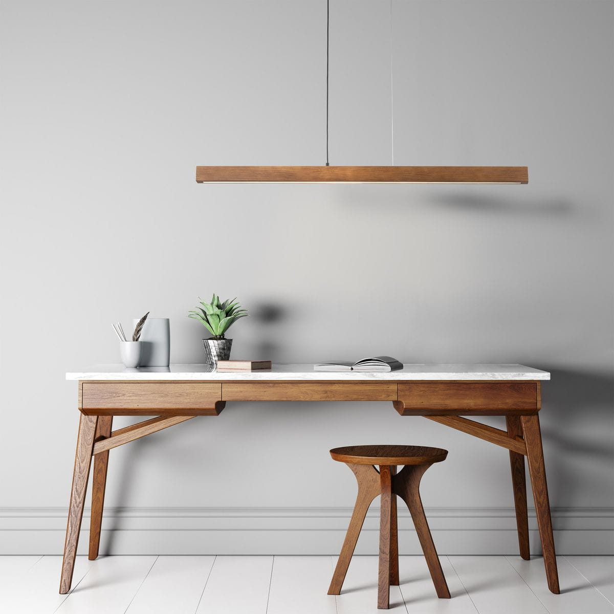 Lampa wisząca Teo w kolorze czarnym z ciemnym drewnem, o prostokątnym kształcie, zawieszona nad drewnianym biurkiem. W tle widoczne rośliny i akcesoria biurowe, na jasnym tle ściany. Idealna do nowoczesnych wnętrz.