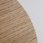 Kinkiet Luna Wood z drewna, o okrągłym kształcie, w naturalnym odcieniu, z widoczną teksturą słojów. Zdjęcie zbliżeniowe na detal powierzchni drewna, na jasnym tle. Widoczne krawędzie i struktura drewna.