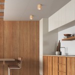 Lampa sufitowa Eve 1xGU10 w jasnym drewnie, zamontowana na suficie w kuchni. Widoczne dwa cylindryczne źródła światła, otoczone drewnianymi panelami i jasnymi elementami zabudowy. Prosta, nowoczesna forma.