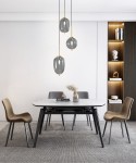 Lampa wisząca Belleville 3xE14 w kolorze czarnym i złotym, z trzema szklanymi kloszami w kształcie owalnym. Zawieszona nad stołem w nowoczesnej jadalni, na tle jasnej ściany. W otoczeniu stylowych krzeseł i dekoracji na półce.