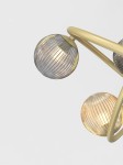 Lampa wisząca Metz w kolorze złotym z 14 oprawkami G9. Widziana z boku, z przezroczystymi kulistymi kloszami o teksturowanej powierzchni, emitującymi ciepłe światło. Klosze umieszczone na eleganckiej, złotej konstrukcji. Tło proste, białe.