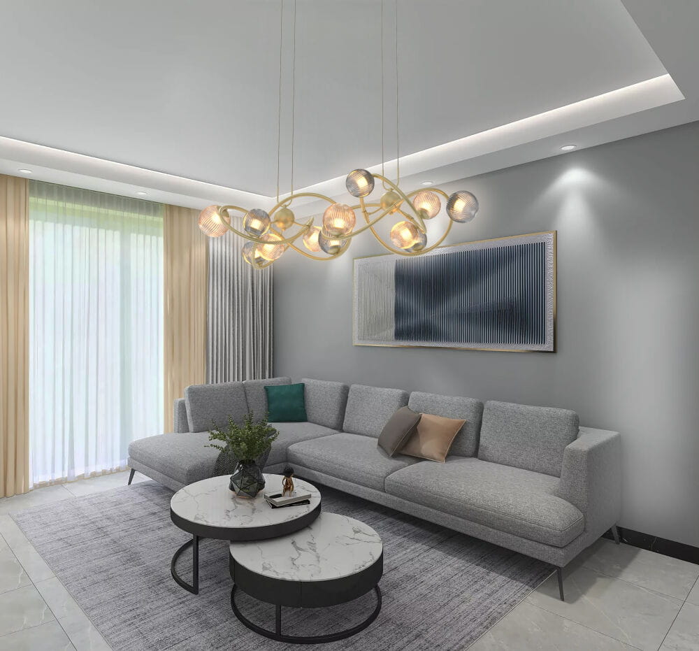 Lampa wisząca Metz w kolorze złotym, z 14 źródłami światła G9, o nowoczesnym, organicznym kształcie. Powieszona w przestronnym salonie nad okrągłym stolikiem kawowym, w otoczeniu szarej kanapy i dekoracyjnych poduszek.