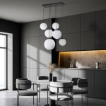 Lampa wisząca Esme z sześcioma białymi kulami na czarnych przewodach, zawieszona na prostokątnej, metalowej podstawie. Produkt umieszczony w nowoczesnym wnętrzu kuchennym z szarymi meblami i minimalistycznym stołem.