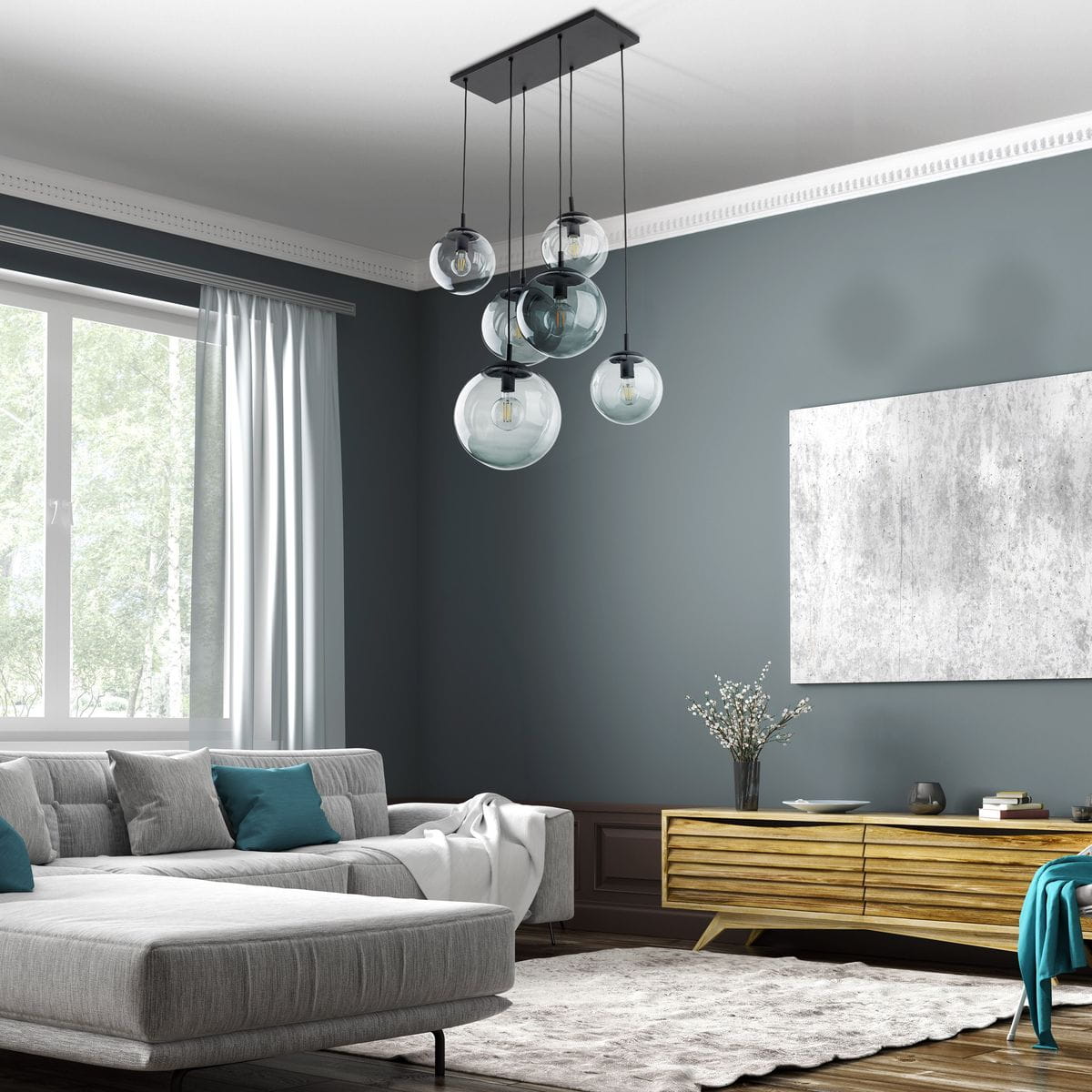 Lampa wisząca Esme z sześcioma oprawami E27 w kolorze czarnym i grafitowym. Wisi na czarnej podstawie, z przezroczystymi kulistymi kloszami w różnych rozmiarach. Umieszczona w nowoczesnym wnętrzu z szarym sofą i drewnianą komodą.