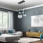 Lampa wisząca Esme z sześcioma oprawami E27 w kolorze czarnym i grafitowym. Wisi na czarnej podstawie, z przezroczystymi kulistymi kloszami w różnych rozmiarach. Umieszczona w nowoczesnym wnętrzu z szarym sofą i drewnianą komodą.