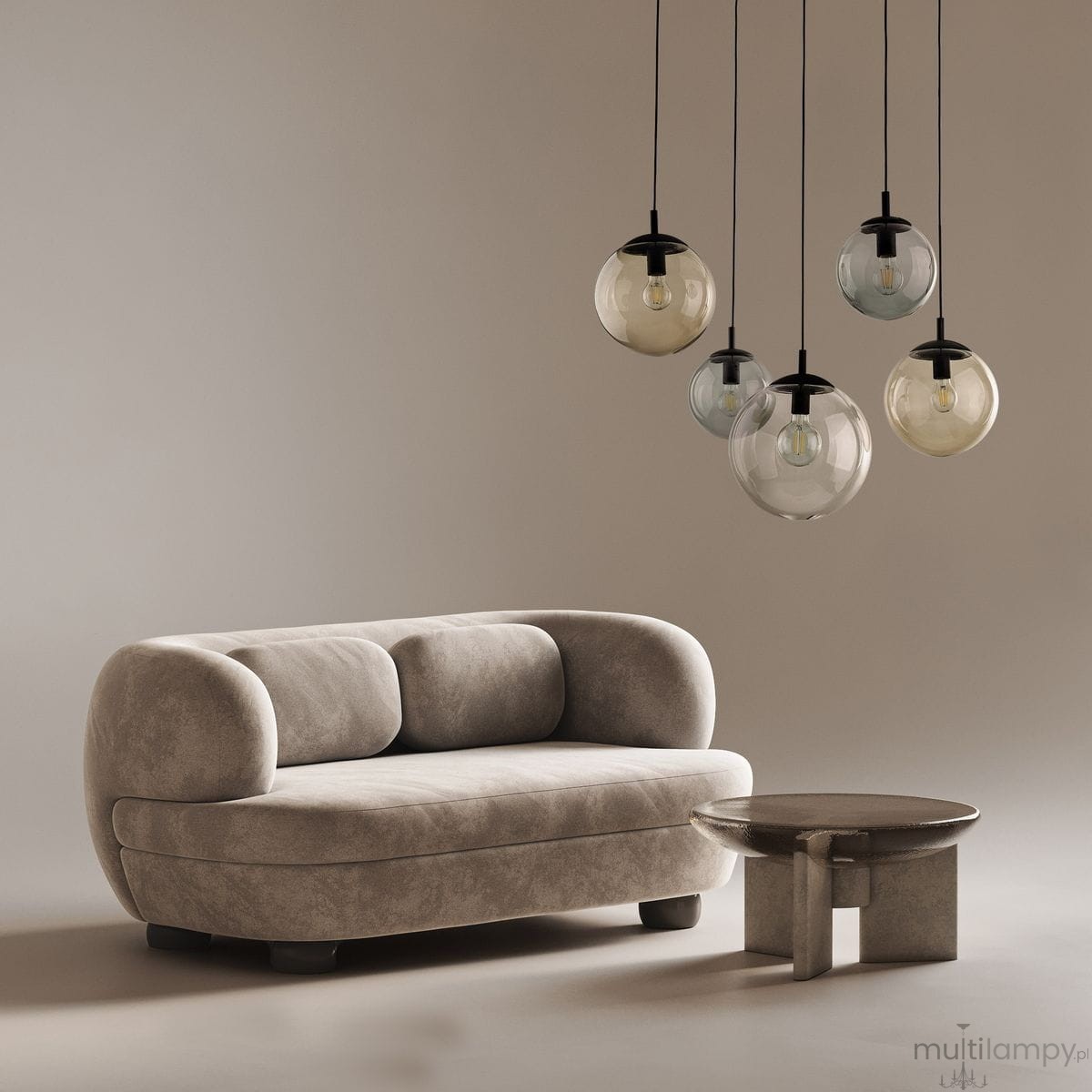 Lampa wisząca Esme z pięcioma kloszami w różnych kolorach, zawieszona na czarnych przewodach. Klosze mają okrągły kształt i są wykonane z przezroczystego szkła. Lampa umieszczona nad jasnoszarym, zaokrąglonym sofą i okrągłym stolikiem.