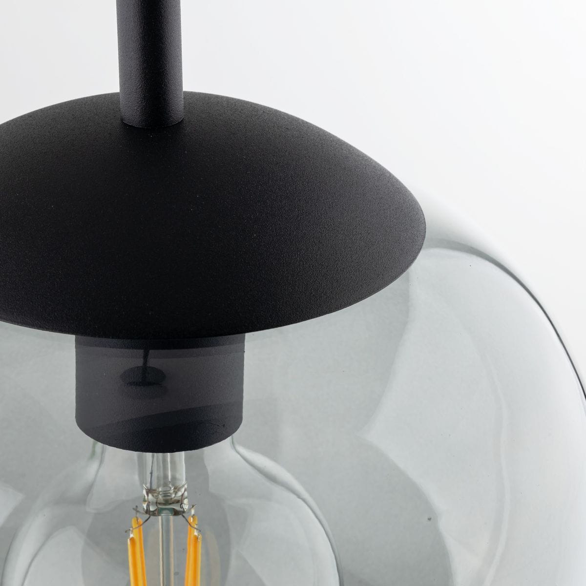 Lampa wisząca Vibe D20 z kloszem w kolorze grafitowym, z czarnym metalowym mocowaniem. Widoczna żarówka E27 z widocznymi elementami wewnętrznymi. Ujęcie z góry, pokazujące detale konstrukcji.
