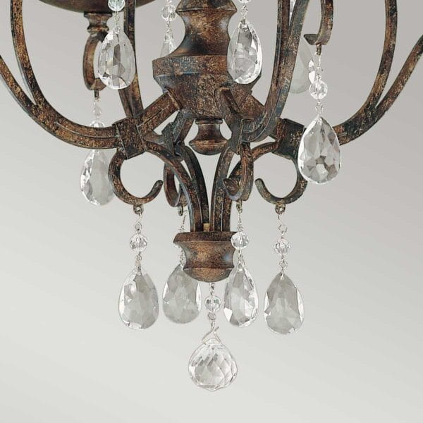 Lampa wisząca Chateau w brązowym, postarzanym wykończeniu z czterema mocowaniami na żarówki E14. Ozdobiona kryształowymi zwisami w kształcie kropli, które dodają elegancji i blasku. Ujęcie z bliska, ukazujące detale konstrukcji.