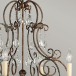 Lampa wisząca Chateau w kolorze brąz postarzany, z sześcioma miejscami na żarówki E14. Ozdobiona kryształowymi wisiorami w kształcie kropli oraz dekoracyjnymi, metalowymi elementami w stylu klasycznym.