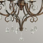 Lampa wisząca Chateau w brązowym, postarzanym wykończeniu, z sześcioma gniazdami E14. Wzór z metalowymi, zakrzywionymi ramionami ozdobionymi przezroczystymi kryształowymi zwisami w kształcie kropli.
