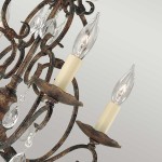 Lampa wisząca Chateau z brązowanego metalu, posiadająca sześć gniazd E14. Ozdobiona kryształowymi elementami i półokrągłymi podstawami na żarówki. Ujęcie z bliska, ukazujące detale mocowania i kształt lampy.