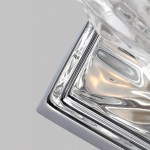 Kinkiet Kalli IP44 z chromowanym wykończeniem, zbliżenie na prostokątną podstawę z lustrzanym efektem. Widoczne detale w postaci gładkiego, błyszczącego metalu oraz zaokrąglone krawędzie, idealny do łazienki.
