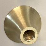 Zbliżenie na metalowy uchwyt lampy wiszącej Artdeco z wykończeniem w złotym szczotkowanym kolorze. Uchwyt ma stożkowy kształt oraz gwint wewnętrzny przystosowany do żarówki E14. Tło proste, białe.