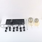 Lampa wisząca Cubus z miejscem na 6 żarówek E27, czarna konstrukcja z kablami. Obok znajdują się szklane klosze w różnych kolorach: przezroczysty, szary i złoty. Produkt leży na białym tle, widoczny z góry, z detalami mocowania i przewodów.