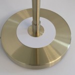 Lampa stołowa Artdeco z trzema gniazdami E14. Podstawa w kolorze złotego szczotkowanego metalu z białym okrągłym elementem w centralnej części. Stojąca, z prostym, eleganckim kształtem, idealna do nowoczesnych wnętrz.