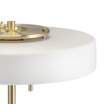 Lampa stołowa Artdeco 3xE14 w kolorze złotym szczotkowanym i białym. Posiada okrągły, biały klosz oraz metalowy złoty element u góry. Ujęcie z boku, ukazujące detale konstrukcji i materiały.