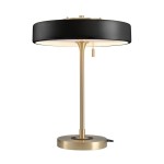 Lampa stołowa Artdeco z trzema gniazdami E14, w kolorze złotym szczotkowanym i czarnym. Okrągły klosz z czarnej tkaniny, metalowy stelaż. Wysoka, z podstawą o średnicy, włącznik na łańcuszku. Ujęcie frontalne, stojąca na jasnym tle.