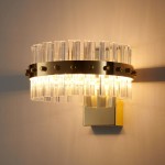Kinkiet Aura 1xLED/8W w kolorze złotym, z przezroczystymi akrylowymi elementami w kształcie prostokątów, zamocowany na prostokątnej, lustrzanej podstawie. Oświetlenie emituje ciepłe światło, tworząc elegancki efekt na ścianie.