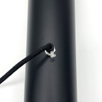 Czarna lampa wisząca Black Tube z dwoma miejscami na żarówki E27. Widać detal mocowania kabla w kolorze srebrnym oraz czarny, matowy korpus lampy. Kąt ujęcia zbliżony na elementy montażowe.