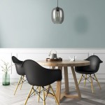 Lampa wisząca Elio 1xE27 w kolorze grafitowym, o zaokrąglonym kształcie, zawieszona nad okrągłym drewnianym stołem. W tle widoczne czarne krzesła i pastelowa ściana. Wnętrze nowoczesne, z dodatkami w jasnych kolorach.
