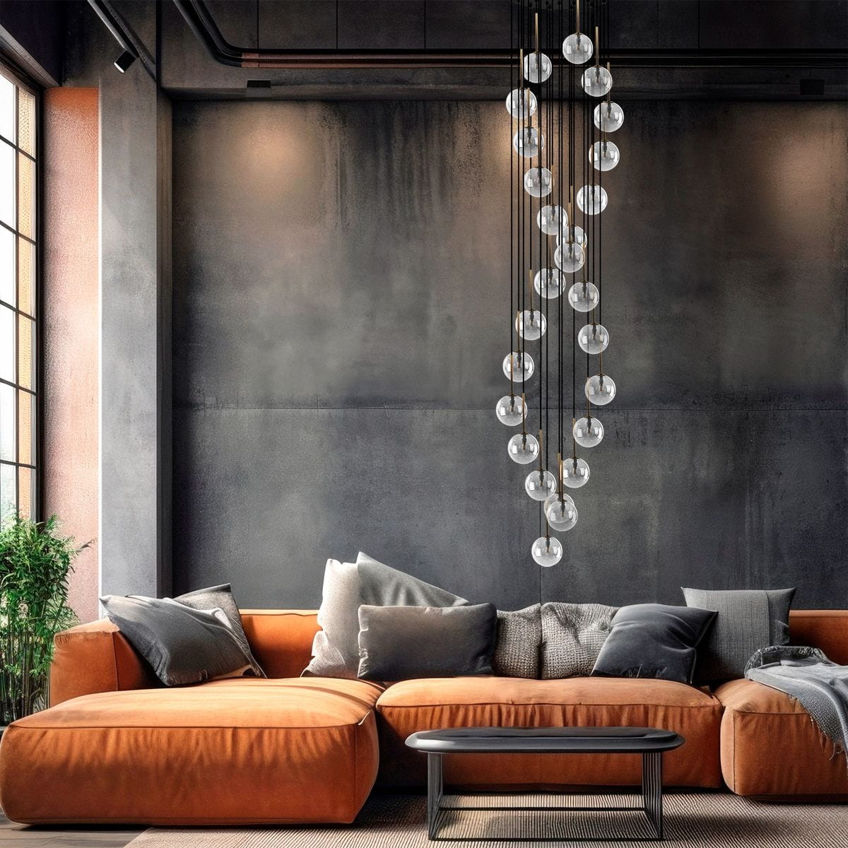 Lampa wisząca Aurora w kolorze czarnym i transparentnym z 26 żarówkami G9, zawieszona w nowoczesnym wnętrzu. W tle widoczna pomarańczowa kanapa z poduszkami oraz stół kawowy. Lampa ma elegancki, minimalistyczny design z okrągłymi kloszami.