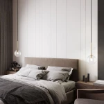 Lampa wisząca Nilos z czarnym kablem i transparentnym kloszem w kształcie kuli, zawieszona nad łóżkiem w sypialni. W tle widoczna jasna ściana i elementy drewniane, w tym szafki nocne oraz dekoracje.