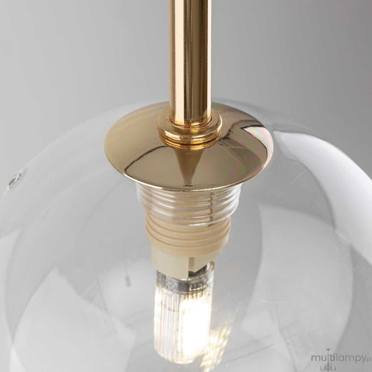 Lampa wisząca Nilos 1xG9 w kolorze czarnym i przezroczystym, z metalowym, złotym mocowaniem. Widoczne detale to kulisty klosz i źródło światła. Ujęcie z góry, ukazujące konstrukcję oraz połączenie klosza z zawieszeniem.