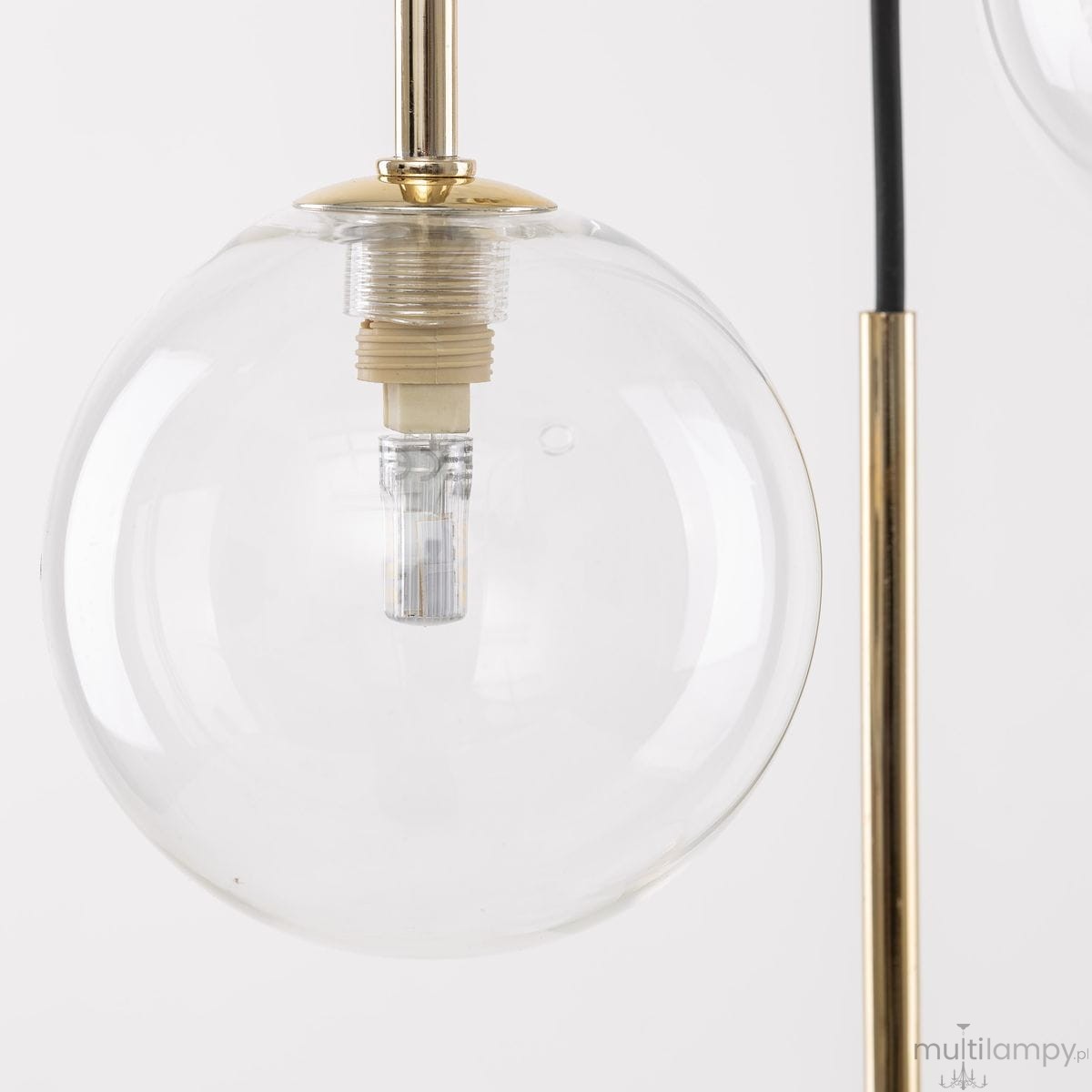 Lampa wisząca Nilos z dziesięcioma gniazdami G9, w czarnej i transparentnej kolorystyce. W zbliżeniu widoczna szklana kula, w której znajduje się oprawka oraz żarówka, umieszczona na złotym elemencie montażowym.