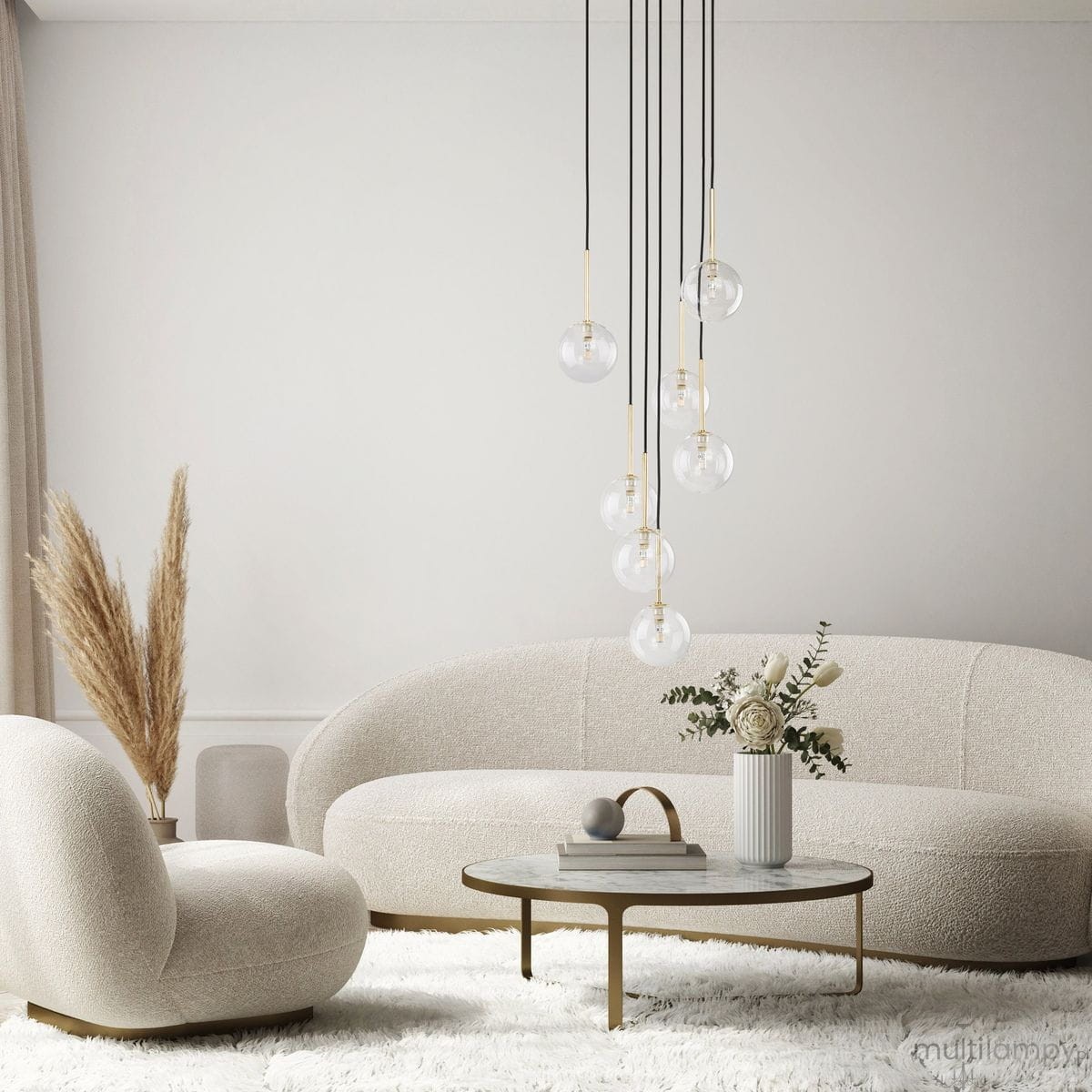 Lampa wisząca Nilos z siedmioma przezroczystymi kulami na czarnych przewodach, zawieszona nad okrągłym stołem w jasnym wnętrzu. Obok widać jasne sofy i dekoracyjne rośliny w wazonie.