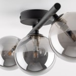 Czarna lampa sufitowa Estera z trzema kulistymi kloszami w grafitowym odcieniu, zamontowana na okrągłej podsufitce. Klosze wykonane z przezroczystego szkła, w których widoczne są źródła światła G9. Ujęcie z bliska, pokazujące detale konstrukcji.