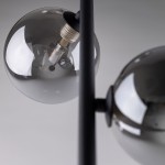 Lampa wisząca Estera 3xG9 w kolorze czarnym i grafitowym. Widoczne szklane klosze w kształcie kul z ciemnym szkłem, mocowanie w czarnym metalowym wykończeniu. Ujęcie z góry, zbliżenie na detale kloszy i źródła światła.