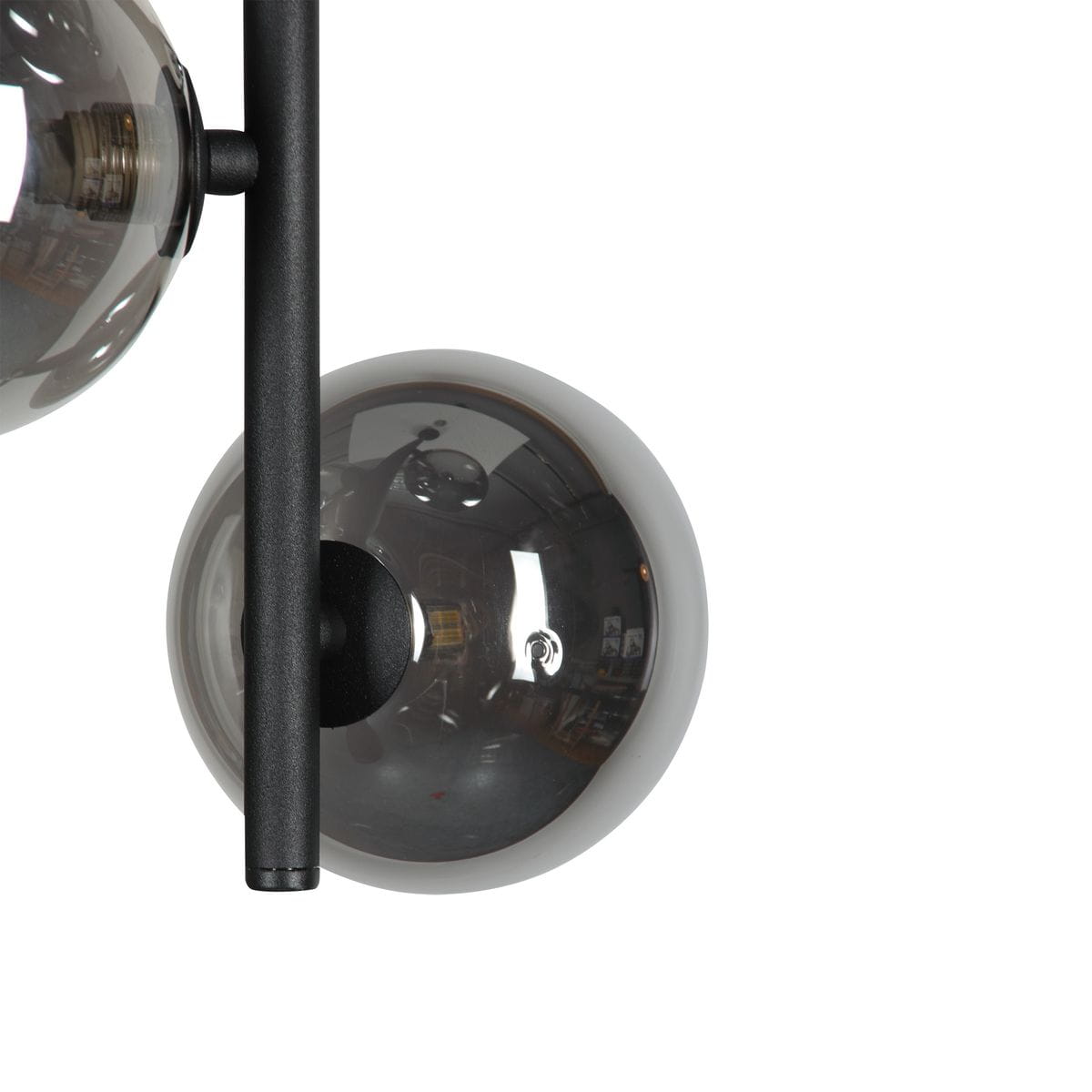 Lampa wisząca Estera w kolorze czarnym i grafitowym, z trzema kulistymi kloszami w odcieniu szaro-przezroczystym. Ujęcie z góry, pokazujące detal łączenia kloszy z metalową konstrukcją. Klosze umieszczone na poziomej linii, elegancki design.