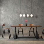 Czarna lampa wisząca Martin z czterema kulistymi kloszami w odcieniu białym, zawieszona nad drewnianym stołem. Lampa o minimalistycznym designie z długimi, czarnymi kabelkami. Tło w odcieniach szarości z elementami drewnianymi.