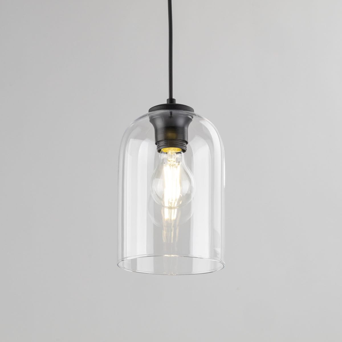 Lampa wisząca Molly z kloszem w kształcie dzwonu, wykonana z przezroczystego szkła. Posiada czarną oprawę z metalowym gwintem E27. Klosz eksponuje żarówkę, tworząc efektowne oświetlenie. Zawieszona na cienkim, czarnym przewodzie.