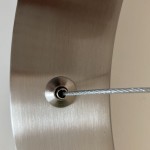 Zbliżenie na mocowanie lampy wiszącej Circle D80 w kolorze niklowym, z widocznym stalowym kablem zawieszenia. Powierzchnia lampy jest matowa, a element mocujący ma okrągły kształt i metaliczne wykończenie.